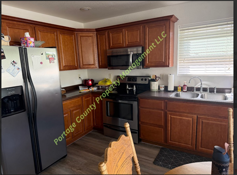 A kitchen with wooden cabinets and a refrigerator.