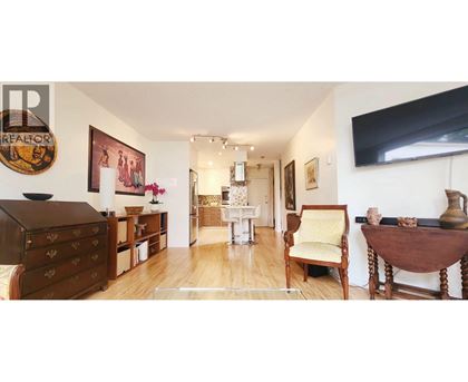 A room with a wooden floor and furniture including a chair and a table.