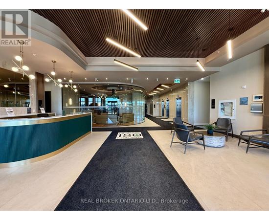 A reception area with a green reception desk and a black carpet.