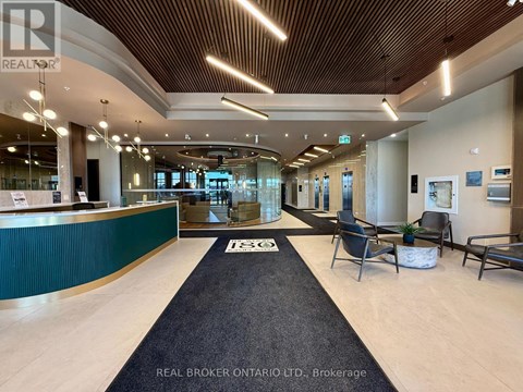 A reception area with a green reception desk and a black carpet.