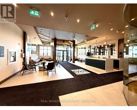 A brokerage office with a black and white carpet and a green reception desk.