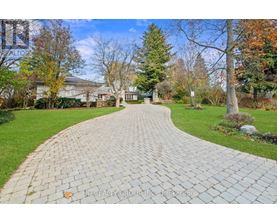 A brick pathway leads through a well-kept garden.