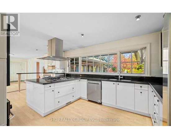 A modern kitchen with white cabinets and a black countertop.