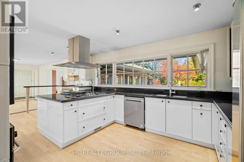 A modern kitchen with white cabinets and a black countertop.