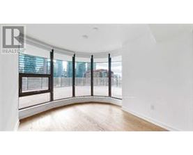 A spacious room with a curved wall and large windows.