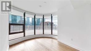 A spacious room with a curved wall and large windows.