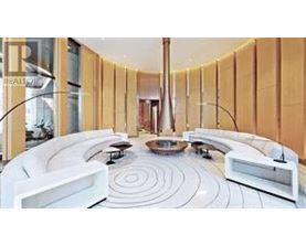 A white circular room with a spiral design on the floor.