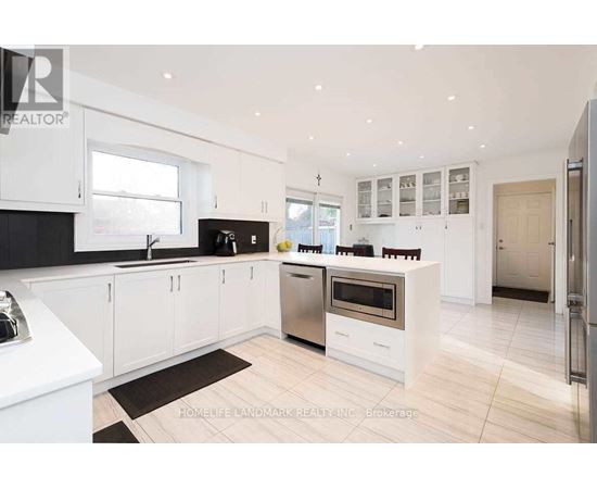 A modern kitchen with white cabinets and a black countertop.