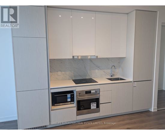 A kitchen with white cabinets and a marble countertop.