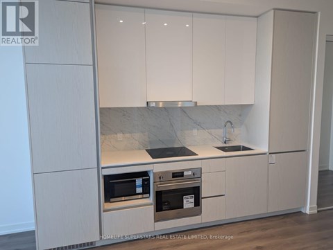 A kitchen with white cabinets and a marble countertop.