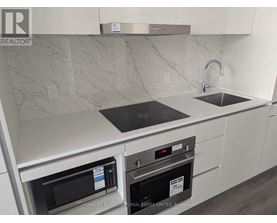 A modern kitchen with a stainless steel oven and microwave.