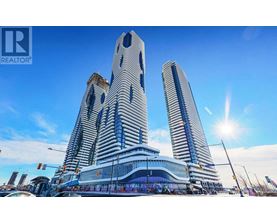 A modern building with a glass facade stands tall against a clear sky.