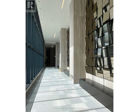 A long hallway with a tiled floor and a wall with a window.