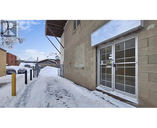 A snowy street with a building on the right and a sign that says "RETAIL".