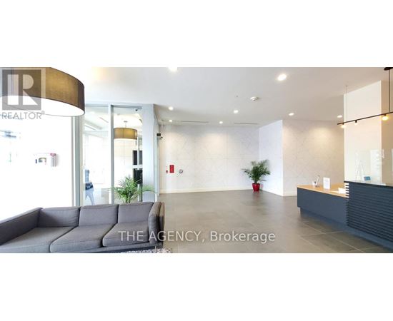 A realtor office with a grey couch and a reception desk.