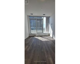A room with wooden flooring and a large window.