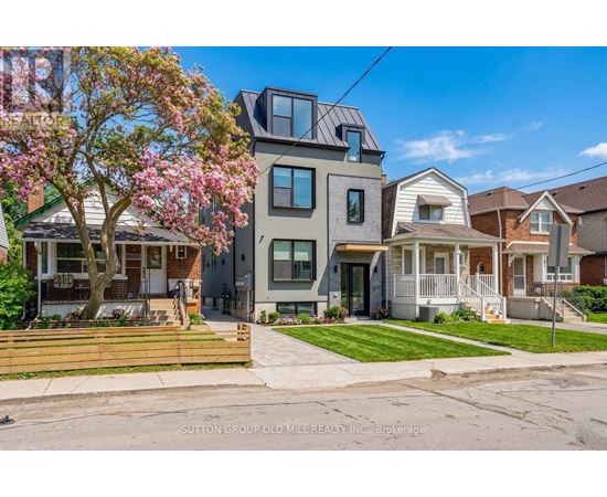 A row of houses with a tree in bloom in front of them.