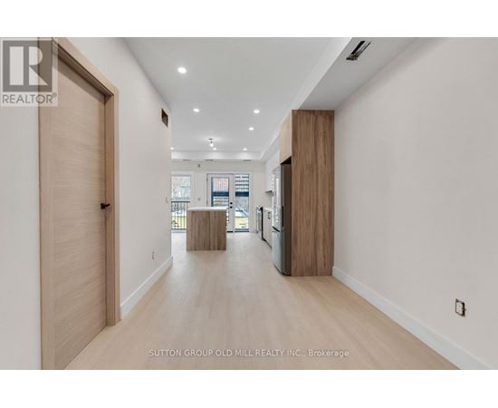 A hallway with wood floors and white walls.