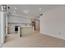 A spacious kitchen with white cabinets and a wooden island.