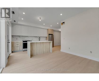 A spacious kitchen with white cabinets and a wooden island.