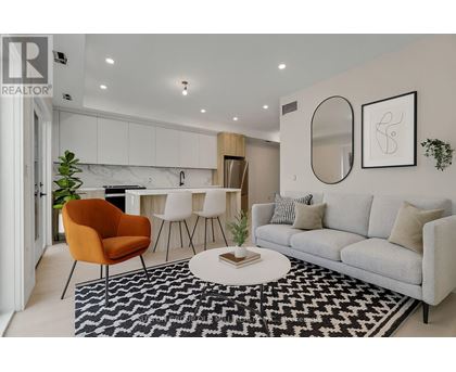 A living room with a grey sofa, a round orange chair and a black and white rug.