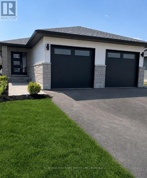 A house with a grey roof and two black garage doors.