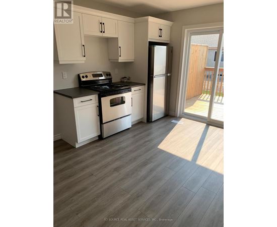 A kitchen with white cabinets and a black stove top oven.