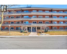 A multi-story apartment building with a parking lot in front.