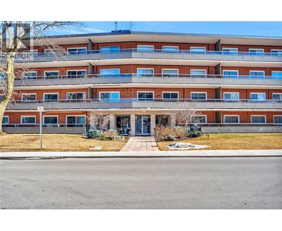 A multi-story apartment building with a parking lot in front.