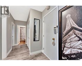 A hallway with a door on the right and a picture of the Eiffel Tower on the wall.