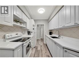 A white kitchen with a wood floor and white cabinets.
