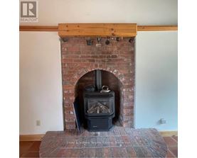 A fireplace with a wooden mantle and a stone base.