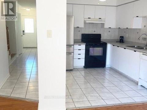 A kitchen with white cabinets and a black oven.