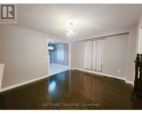 A spacious room with wooden floors and a doorway leading to another room.