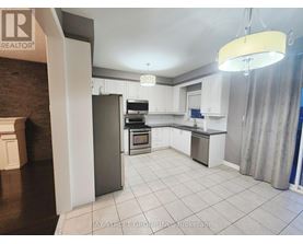A kitchen with white cabinets and a refrigerator.