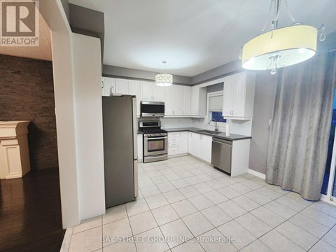 A kitchen with white cabinets and a refrigerator.
