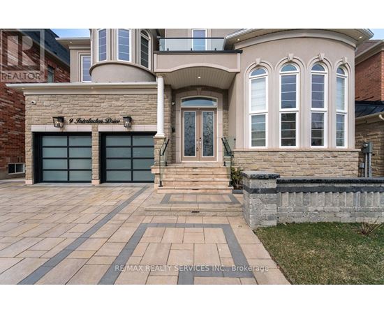 A large house with a brick wall and a garage door.
