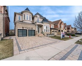 A large, multi-story house with a driveway in front.