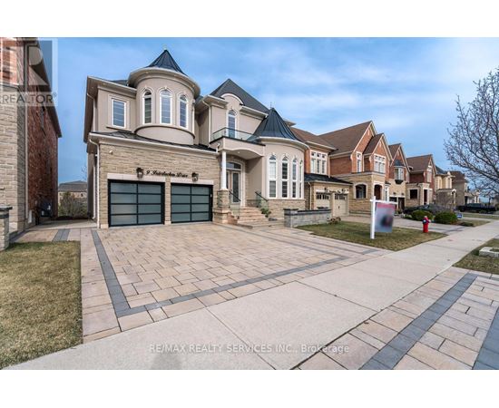 A large, multi-story house with a driveway in front.