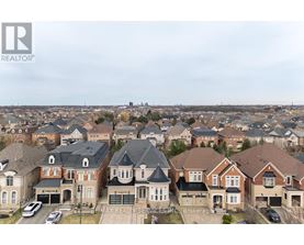 A real estate company logo is displayed on a cloudy day over a residential neighborhood.