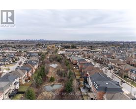 A bird's eye view of a residential area with houses and a pond.