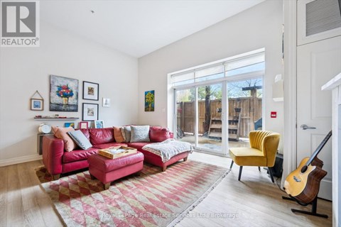 A living room with a red couch and a guitar.
