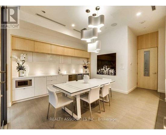 A modern dining room with a white table and chairs.
