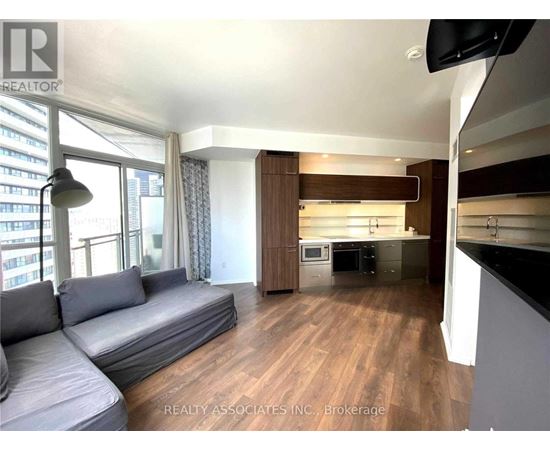 A living room with a grey sofa and a television.