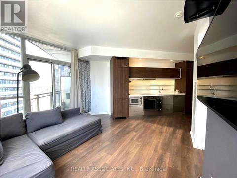 A living room with a grey sofa and a television.