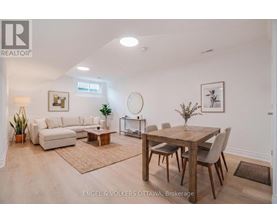 A well-lit, spacious living room with a dining area and a white sofa.