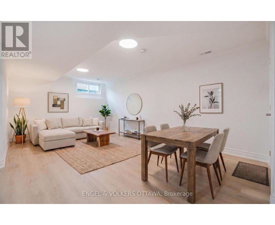 A well-lit, spacious living room with a dining area and a white sofa.