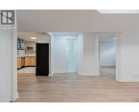 A spacious, empty room with a black cabinet and a white door.