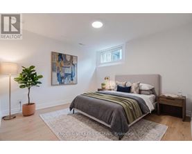 A bedroom with a bed, nightstand, and lamp.