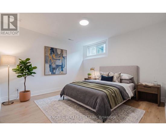 A bedroom with a bed, nightstand, and lamp.